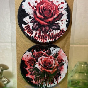 May include: Two round car coasters with a black background and red roses. The top coaster has the text "My Little Mouse" and the bottom coaster has the text "Mischief".
