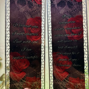 May include: Two silver bookmark holders with a skull and red roses design. The text on the bookmarks reads: "Without you, I will shatter. But with you, I am indestructible." and "If any redemption resides somewhere within you, then I will spend the rest of my life searching for it inside of you. Haunting Adeline."