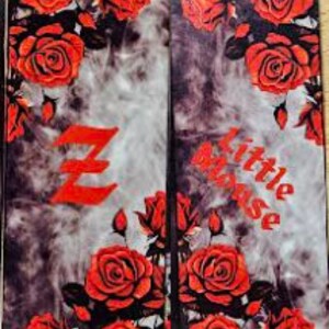 May include: Two black and gray bookmark with a red rose pattern. The left bookmark has a red letter Z and the right bookmark has the word "little blouse" in red.