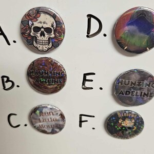 Puede incluir: Seis botones diferentes con varios dise&ntilde;os. Los botones son redondos y tienen un acabado brillante e iridiscente. Los dise&ntilde;os incluyen una calavera con flores, un dise&ntilde;o de texto que dice "Haunting Adeline", un dise&ntilde;o de texto que dice "Hunting Adeline", un dise&ntilde;o de texto que dice "Run Little Mouse", un dise&ntilde;o con una figura encapuchada y un dise&ntilde;o con una calavera y flores.