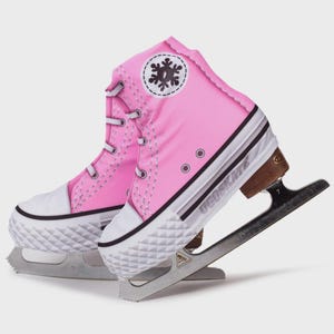 May include: A pair of pink ice skates styled like high-top trainers. They feature white laces, a white toe cap, and a black and white stripe on the sole. A snowflake logo is visible on the side.