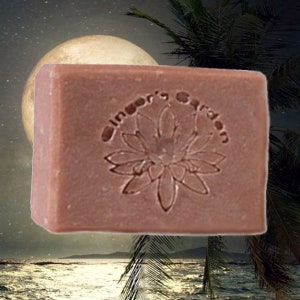 May include: A rectangular bar of soap with a brown color and a floral design. The soap has the text "Ginger's Garden" embossed on it.