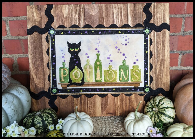 May include: Cross-stitch artwork featuring a black cat with green eyes sitting in front of potion bottles. The word "POTIONS" is displayed in green letters. The artwork is framed with a wooden border and black accents, perfect for Halloween decor.
