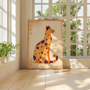 May include: A framed illustration of a spotted cat sitting with its tail curled around its legs. The cat is yellow with purple spots and is set against a beige background.