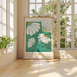May include: A framed poster with a green background and white flowers. The poster says "Flower Market Los Angeles" and "Botanical Archive" at the bottom.