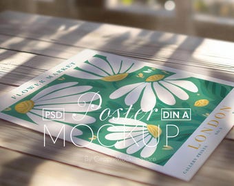Könnte beinhalten: Ein Poster-Mockup mit einem floralen Design aus großen weißen Gänseblümchen und gelben Akzenten auf grünem Hintergrund. Das Poster enthält den Text "Flower Market" und "London" mit den Worten "Poster Mockup" in einer stilisierten Schriftart. Das Poster wird auf einer Holzoberfläche präsentiert.