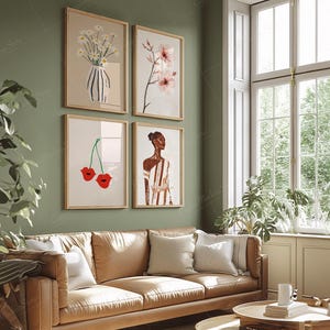 Peut inclure: Quatre impressions d'art encadr&eacute;es avec des th&egrave;mes botaniques et figuratifs. Les impressions pr&eacute;sentent un vase de fleurs, des branches florales roses, une paire de cerises rouges et une femme dans une robe ray&eacute;e. Les cadres sont brun clair et le mur est vert olive.