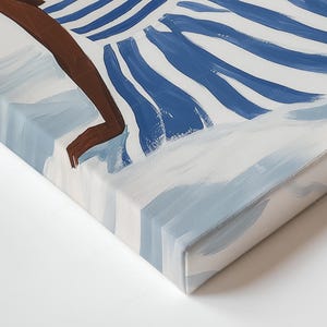 May include: Abstract canvas art print depicting a person in water. The painting uses white, light blue, and dark blue. The person's arm and leg are visible, with dark brown skin. The water is represented with blue and white brushstrokes.