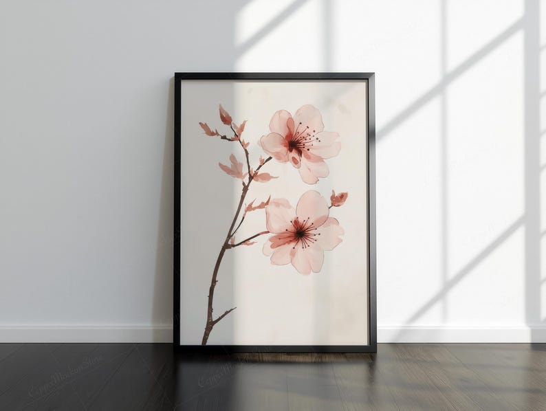 May include: A framed art print with a watercolour illustration of cherry blossoms. The artwork depicts delicate pink flowers with dark red centres and a brown stem against a cream background. The black frame adds a modern touch.