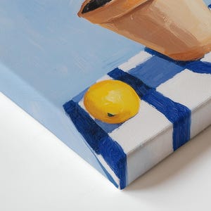 May include: A still life painting showing a terracotta pot and two yellow lemons on a blue and white chequered surface. The background is a light blue, and the artwork is viewed from a side angle.