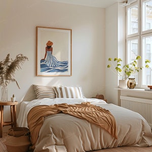 May include: A bedroom scene with a large framed artwork depicting a woman in a striped dress and hat. The bed is made with neutral-toned bedding and a brown throw blanket. A small wooden stool and a vase with dried plants are also visible.