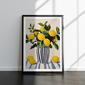 May include: A framed art print depicting a still life of lemons. The lemons are yellow and are in a black and white striped vase. The vase is on a blue and white striped surface. The print is in a black frame.