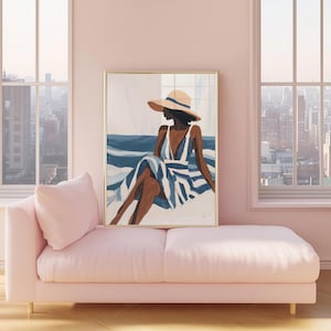 May include: An art print in a gold frame depicts a person in a hat and striped dress, seated near blue water. The artwork hangs above a pink chaise lounge. The room has large windows with a city view.