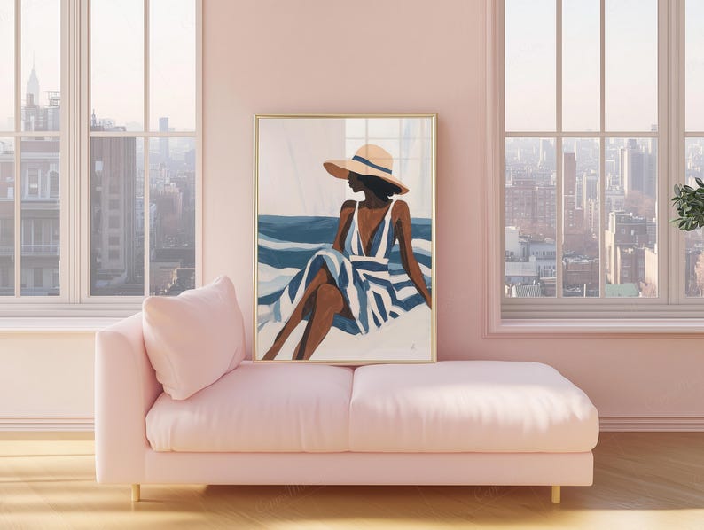 May include: An art print in a gold frame depicts a person in a hat and striped dress, seated near blue water. The artwork hangs above a pink chaise lounge. The room has large windows with a city view.