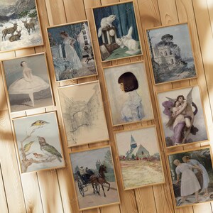May include: A collection of framed vintage art prints. The prints feature various scenes, including landscapes with deer, portraits, and classical figures. The frames are a light wood color, and the prints are displayed on a wooden surface.