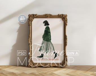 May include: A gold ornate frame with a white mat and a print of a woman in a green and white striped dress. The frame is on a wood floor.