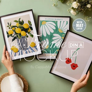 Könnte beinhalten: Drei gerahmte Drucke mit verschiedenen Designs. Der erste Druck zeigt eine Vase mit Zitronen auf einem gestreiften Hintergrund. Der zweite Druck zeigt ein florales Design mit weißen Blumen auf grünem Hintergrund. Der dritte Druck zeigt eine rote Kirsche mit einem grünen Stiel auf hellgrauem Hintergrund. Der Text "DIN A" ist auf dem dritten Druck sichtbar.