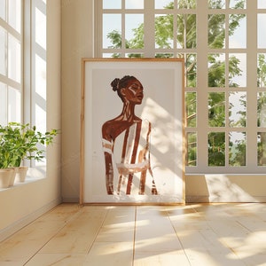 May include: A framed illustration of a person with brown skin and white and brown striped clothing. The person has dark hair and is looking to the right. The background is a light beige color.
