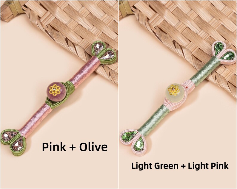 Op de afbeelding: Twee decoratieve Hanbok-knoppen, &eacute;&eacute;n roze en olijf, de andere lichtgroen en lichtroze. Elke knop heeft een centrale bloemversiering en hartvormige kristallen accenten. De tekst "Pink + Olive" en "Light Green + Light Pink" is zichtbaar.
