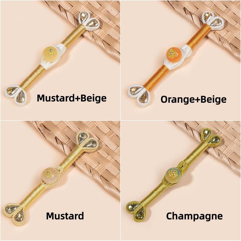 Op de afbeelding: Vier decoratieve knevelsluitingen in mosterd-, oranje- en champagnekleuren. Elke sluiting heeft een centrale knop en hartvormige uiteinden met kristallen accenten. De tekst op de afbeelding luidt "Mustard+Beige", "Orange+Beige", "Mustard" en "Champagne".