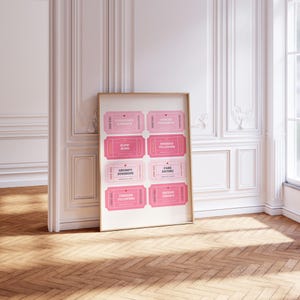 May include: A framed print featuring eight pink ticket designs with phrases like "Forbidden Romance" and "Fake Dating." The tickets have a vintage aesthetic with a light pink background and darker pink text. The print is displayed against a white wall.