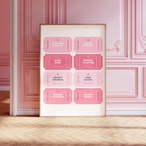 May include: A framed print featuring eight pink love coupons with phrases like "Forbidden Romance" and "Fake Dating." The coupons have a vintage ticket design with a heart and the words "Made with Love." The print is displayed against a pink wall.