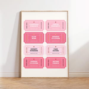 May include: A framed print featuring eight pink love coupons with phrases like "Forbidden Romance" and "Fake Dating." Each coupon has a heart and the words "Made with Love."