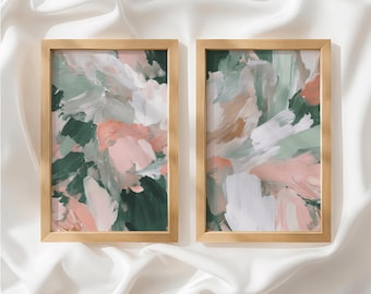May include: Two rectangular wall art pieces in light wood frames featuring abstract brushstrokes in shades of forest green, soft pink, white, and muted tan. The paintings display thick, layered paint textures with visible directional strokes across the canvas.
