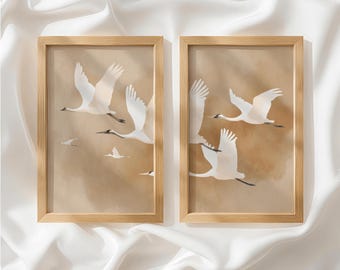 May include: Two rectangular wall art prints in light wood frames, each featuring a series of white cranes in flight against a soft, muted tan background. The birds are depicted with outstretched wings and black accents on their heads and tails.