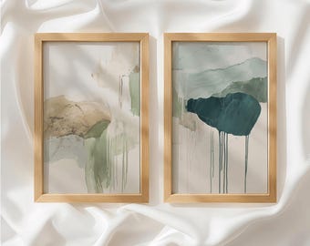 May include: Two vertical rectangular wall art prints in light wood frames. The left print features abstract washes of sage green, beige, and tan with vertical paint drips. The right print displays a dark teal shape over muted green and beige tones.