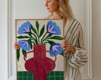 May include: A framed floral art print featuring a burgundy vase with blue flowers and green leaves. The vase sits on a green checkered pattern, with a cream-colored background. The artwork is displayed in a natural wood frame.