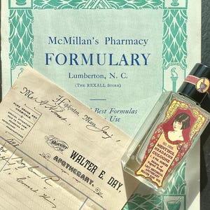 May include: An antique apothecary display featuring a vintage bottle of Menthol Headache Cologne, a pharmacy formulary, and an old receipt. The cologne bottle has a red and gold label with a woman's portrait. The formulary is green and white.