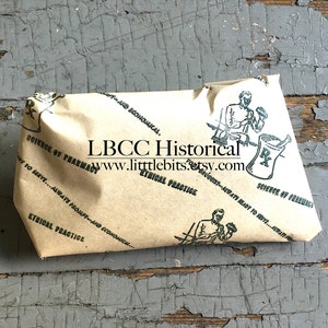 Puede incluir: Un paquete envuelto en papel marr&oacute;n con ilustraciones verdes y texto, incluyendo "Ciencia de la farmacia" y "Pr&aacute;ctica &eacute;tica". El paquete est&aacute; sobre una superficie gris desgastada. El texto "LBCC Historical" y una direcci&oacute;n web tambi&eacute;n son visibles.