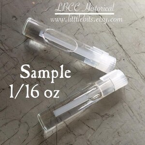 Peut inclure: Deux flacons d'&eacute;chantillon en verre transparent avec des bouchons blancs, chacun contenant un liquide clair. Les flacons sont &eacute;tiquet&eacute;s "Sample 1/16 oz". Le texte "LBCC Historical www.littlebits.etsy.com" est &eacute;galement visible.