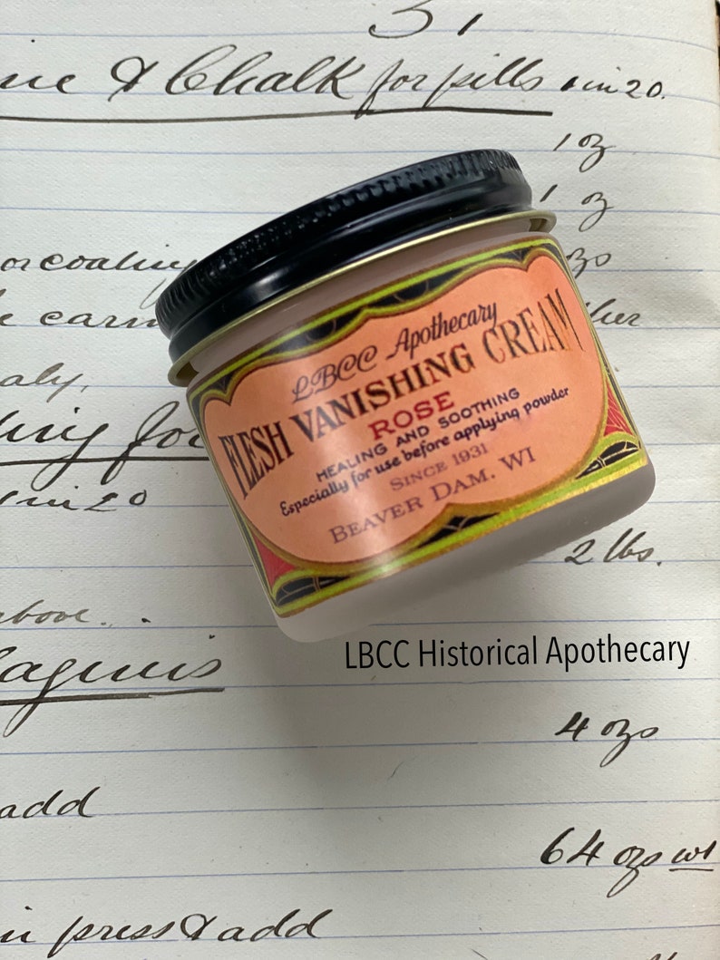 May include: A small glass jar of LBCC Apothecary Flesh Vanishing Cream Rose. The label is peach-colored with red and gold accents. Text on the label includes "Healing and Soothing" and "Since 1931, Beaver Dam, WI."