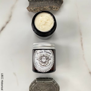 May include: A small glass jar with a silver lid containing Sultana Pomatum, a cream to cleanse and preserve the complexion. The jar has a label with the text "Sultana Pomatum", "Apothecary 1772", and "Cleanse & Preserve the Complexion".