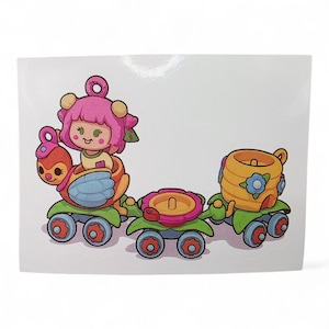 Puede incluir: Una colorida pegatina con un tren de dibujos animados con tres vagones. El primer vagón tiene un personaje con pelo rosa montado en un vehículo con forma de pájaro. El segundo vagón es una flor, y el tercero es una colmena. Todos los vagones tienen ruedas verdes.