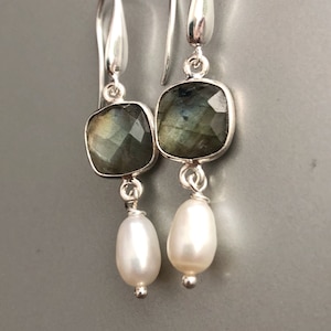 May include: Silver dangle earrings with a square labradorite gemstone and a white pearl drop.