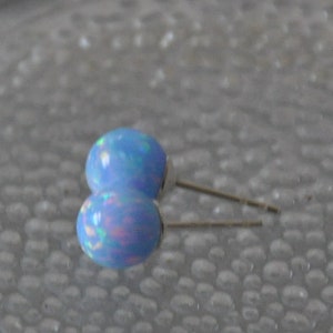 May include: A pair of blue opal stud earrings with silver posts.