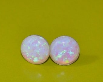 May include: A pair of white opal stud earrings with a shimmery iridescent finish.