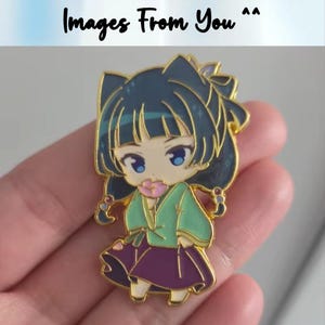 May include: A gold-colored enamel pin featuring a cartoon character with dark blue hair and a green and purple outfit. The pin has a flower in its mouth and the text "Images From You" at the top.