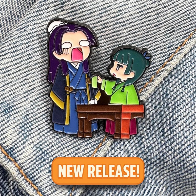 May include: Enamel pin featuring two anime-style characters in traditional clothing. One character is in blue and purple, the other in green and red. The pin is set against a denim background, with an orange "NEW RELEASE!" banner.