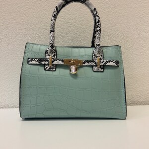 Bolso de hombro de charol verde celadón con asa superior en blanco y negro
