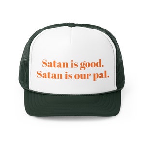 May include: A white and green trucker hat with the text "Satan is good. Satan is our pal." in orange.