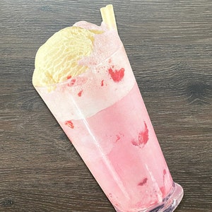 May include: A pink strawberry milkshake with whipped cream and a straw in a clear glass. The milkshake is topped with a scoop of vanilla ice cream.