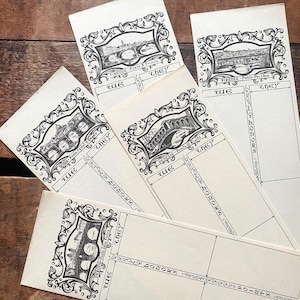 May include: Several vintage paper cards with black and white illustrations of bridges in Italy. Each card features a different bridge design within an ornate frame, with text including "FIRENZE" and "VERONA". The cards are arranged on a wooden surface.