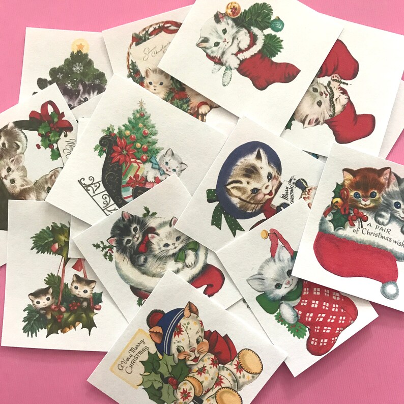 May include: A collection of vintage Christmas cards featuring kittens in various holiday scenes. The cards are printed on white paper with red and green accents. Some of the cards feature kittens wearing Santa hats, others feature kittens in stockings, and others feature kittens with Christmas trees. The cards are all in good condition and would make a great addition to any Christmas collection.