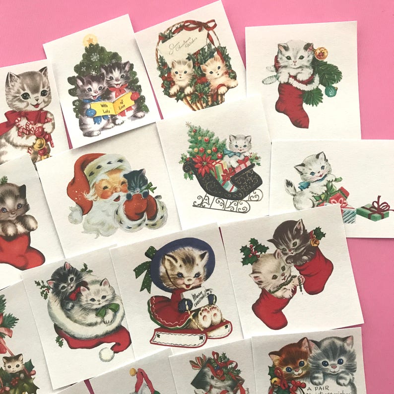 May include: A set of 12 vintage Christmas cards featuring kittens in various holiday scenes. The cards are printed on white cardstock and feature colorful illustrations of kittens wearing Santa hats, riding in a sleigh, and decorating a Christmas tree. The cards are perfect for adding a touch of whimsy to your holiday decor.