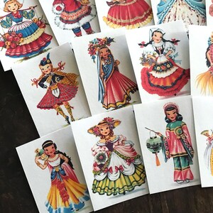 Peut inclure: Ensemble de 10 cartes illustr&eacute;es vintage repr&eacute;sentant des filles en costumes traditionnels de diff&eacute;rents pays. Chaque carte pr&eacute;sente une fille diff&eacute;rente dans une robe color&eacute;e, tenant un accessoire li&eacute; &agrave; sa culture. Les cartes sont imprim&eacute;es sur du papier cartonn&eacute; blanc et sont en excellent &eacute;tat.