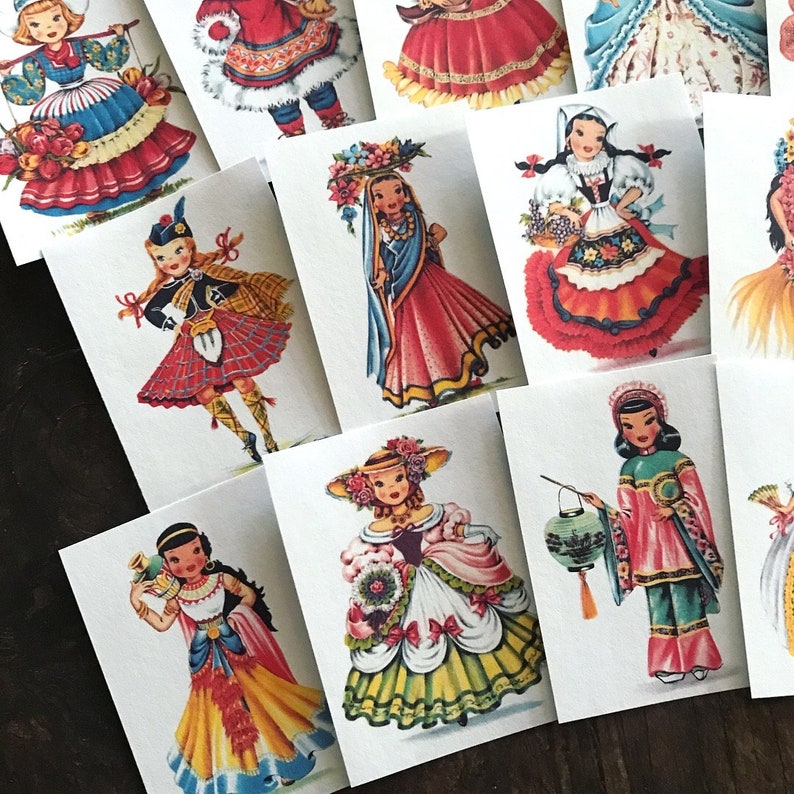 Peut inclure: Ensemble de 10 cartes illustr&eacute;es vintage repr&eacute;sentant des filles en costumes traditionnels de diff&eacute;rents pays. Chaque carte pr&eacute;sente une fille diff&eacute;rente dans une robe color&eacute;e, tenant un accessoire li&eacute; &agrave; sa culture. Les cartes sont imprim&eacute;es sur du papier cartonn&eacute; blanc et sont en excellent &eacute;tat.